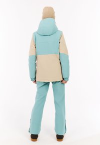 Türkise und beige Skijacke mit Kapuze, elastischen Bündchen und Schneeanzug in passender Farbe, mit lässiger Passform und seitlichen Reißverschlüssen.