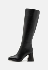 Black knee-high boot made of smooth leather, featuring a square toe and a chunky, textured heel. Simple and streamlined design.