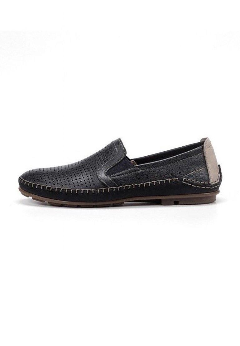 Zapatos negros sin cordones con parte superior de cuero perforado, tacón gris en contraste y detalle de costura beige a lo largo de la suela. Suela de goma plana.