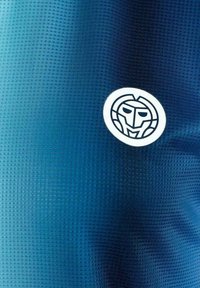 Tela azul texturizada con un pequeño logotipo circular blanco que presenta una cara minimalista estilizada en líneas negras.