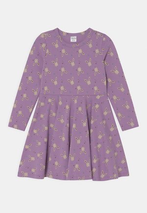 Fioletowa sukienka dziecięca z długim rękawem i rozkloszowaną spódnicą, ozdobiona wzorem beżowych główek króliczków oraz małych rozproszonych trójkątów.