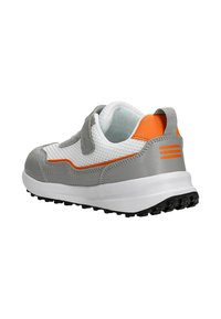 Baskets de sport grises avec une tige en maille et des accents synthétiques. Présentent un détail orange, une fermeture à bande Velcro et une semelle en caoutchouc avec un motif texturé.