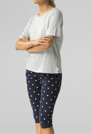 Szary t-shirt z krótkim rękawem w połączeniu z granatowymi spodniami 3/4 w duże białe grochy. Strój wykonany jest z miękkiego, wygodnego materiału.