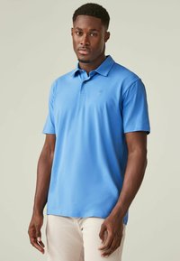 Helles blaues Poloshirt aus glattem Stoff, mit klassischem Kragen und kurzen Ärmeln, versehen mit einem kleinen Logo auf der linken Brust.