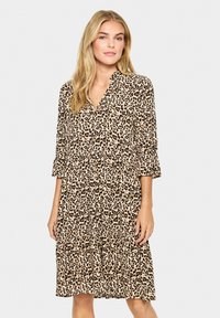 Rochie cu imprimeu leopard, cu decolteu în V, mâneci trei sferturi și talie strânsă. Fabricată dintr-un material ușor, cu o siluetă fluidă.