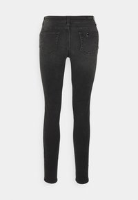 Jeans ajustados negros de mezclilla, con un diseño clásico de 5 bolsillos, cintura media y una textura suave.