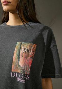 Hallharjasest puuvillane T-särk, millel on elav Degase kunstiteose trükk, allpool on tekst "DEGAS" ja "MFA Boston". Lühikesed varrukad ja mugav lõige.