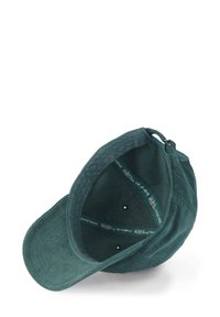 Casquette en velours côtelé vert avec une texture douce, une visière incurvée et une sangle ajustable. L'intérieur comporte une étiquette de logo et cinq trous de ventilation.