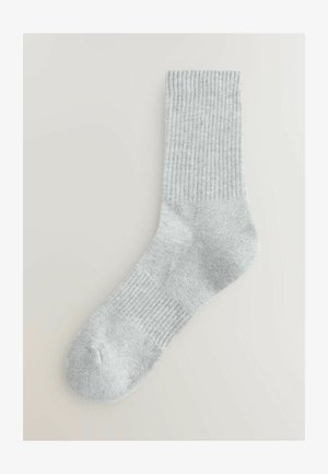Svetlo šedá ponožka s rebrovanou textúrou, v dĺžke po členky, s vystuženou špičkou a pätou, vyrobená z mäkkej látky, vhodná na bežné nosenie.