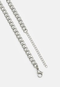 Silver metal chain with interlocking links, featuring a lobster clasp and an extension chain for adjustable length. Smooth texture.