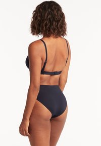 Marineblauwe bikini-set met een strakke, minimalistische uitstraling, verstelbare bandjes en hoge taille broekjes. Glad, textuurstof.