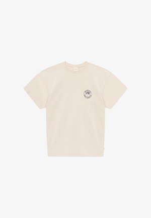T-shirt à manches courtes couleur crème avec un petit logo rond noir représentant un palmier et du texte sur le côté gauche de la poitrine.