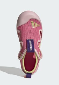 Ružová sieťovaná detská topánka s gumovým špičkovým krytom, limetkovo zelenými akcentmi a fialovým brandingom na päte; má výrezy pre priedušnosť.