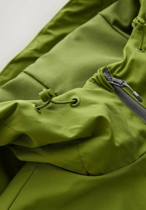 Green outdoor jacket featuring smooth, textured fabric with adjustable drawstrings and a zippered pocket for secure storage.