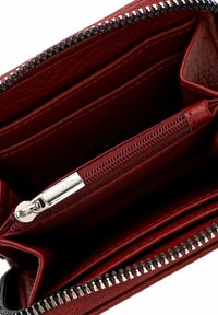 Innenansicht eines roten Lederportemonnaies mit mehreren Kartenfächern, einem zentralen Reißverschlussfach mit silbernem Reißverschlussanhänger und einem schwarzen Reißverschlussverschluss.