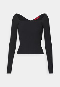 Haut noir à manches longues côtelé avec une silhouette ajustée, présentant un décolleté en V profond et un ourlet légèrement évasé. Étiquette de marque rouge mentionnée.