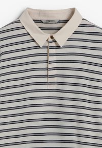 Polo de manga corta en crema con rayas horizontales marino, que presenta un collar suave, tapeta de tres botones y finos detalles de costura.