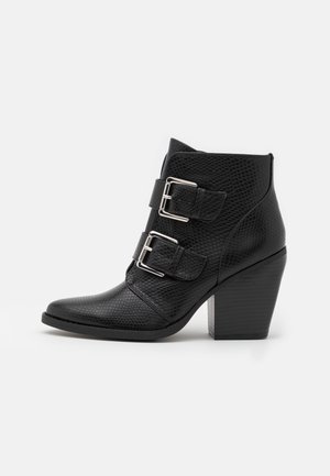 Svarta ankelboots med en texturerad yta i reptilmönster. Utrustade med två silverfärgade spännband och en robust, fyrkantig klack. Spetsig tå.