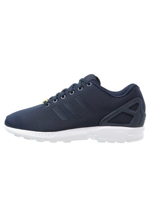 Baskets athlétiques bleu foncé avec tige en mesh, bandes noires sur le côté, lacets noirs et semelle en caoutchouc blanche.