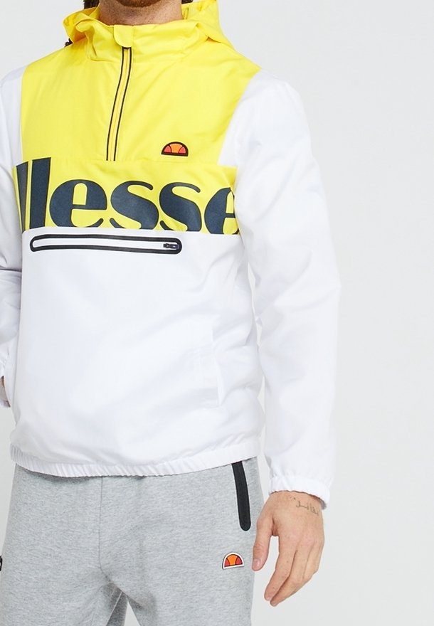 White and yellow windbreaker jacket with a hoodie, featuring a large logo, half-zip front, and a zipper pocket. Elastic cuffs and hem.