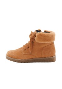 Tan suède enkelboots met een bontkraag, vetersluiting aan de voorkant en een gestructureerde rubberen zool, afgebeeld in profiel op een witte achtergrond.