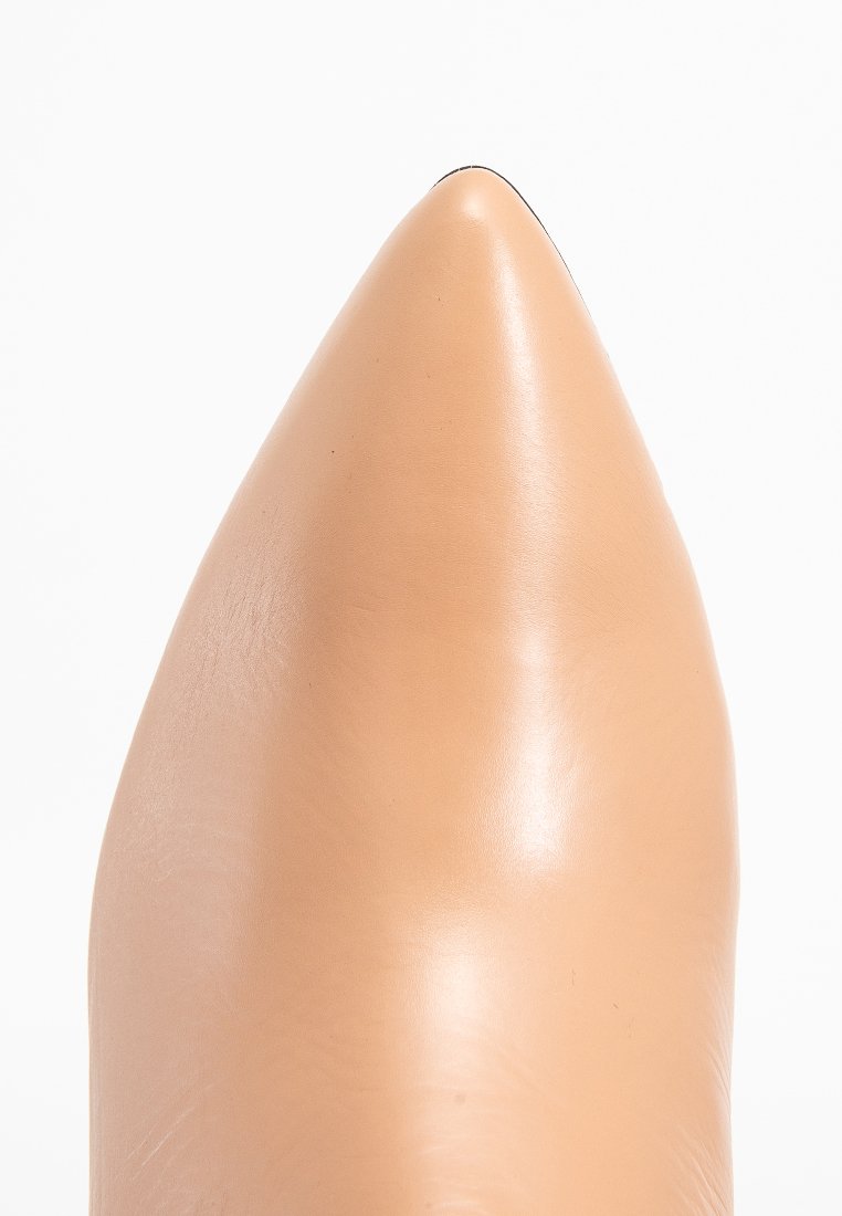 Beiger Lederschuh mit spitz zulaufender Spitze, glatter Textur und glänzendem Finish. Der Schuh zeichnet sich durch eine elegante Silhouette mit scharfem Zehendesign aus.