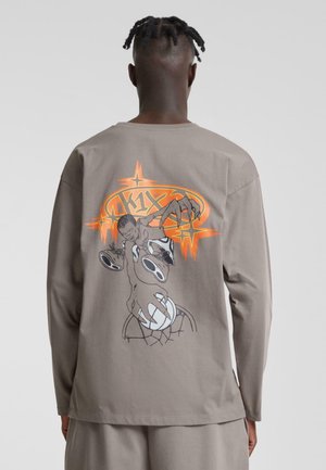 Lange mouwen shirt in lichtgrijze katoen met een gedurfde grafische print op de achterkant, met een karakter dat naar basketbal te ballen reikt in zwart en oranje accenten.