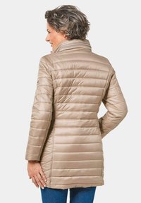 Beige pufferjas met horizontaal gestikte ontwerpen, hoge kraag en zijzakken, van achteruit weergegeven, met een gladde, glanzende textuur.