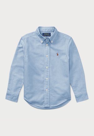 Hellblaues langärmliges Hemd aus Baumwolle mit Knopfleiste. Verfügt über einen klassischen Kragen, weiße Knöpfe und ein Emblem auf der Brust.