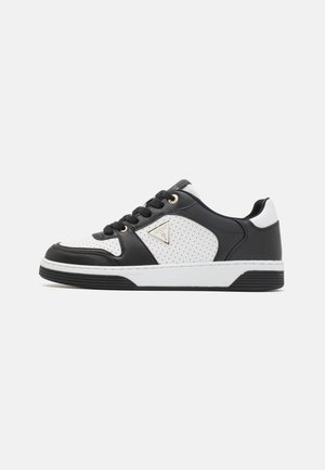 Scarpe sportive in bianco e nero con tomaia in pelle texturizzata, dettagli perforati, hardware in tono oro e suola in gomma a contrasto.