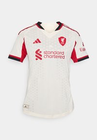 Bela nogometna majica z rdečimi detajli, z v-izrezom, kratkimi rokavi, šesterokotno vzorcem, logotipom L.F.C. in besedilom "Standard Chartered".
