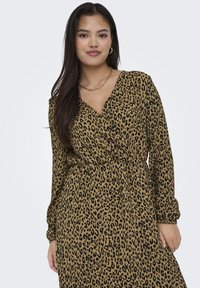 Obliekanie s leopardím vzorom v béžovej a čiernej farbe, s dlhými rukávmi, výstrihom do V a zúženým pásom pre telesne priliehavý strih.