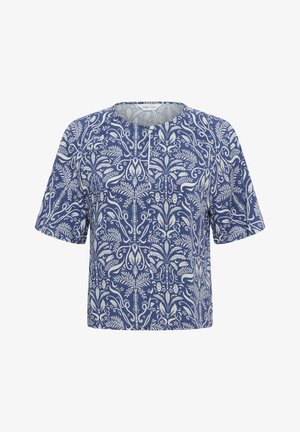 Blusa blu a maniche corte con motivo bianco intricato floreale e di vite e un piccolo bottone frontale vicino allo scollo rotondo.