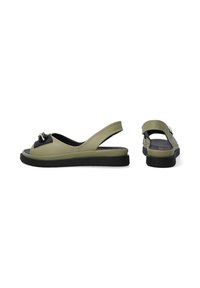Olivgrüne Slingback-Sandalen mit schwarzen Akzenten, flacher Sohle und dekorativem Schleifendetail an der Vorderseite. Weiches Material mit glatter Textur.