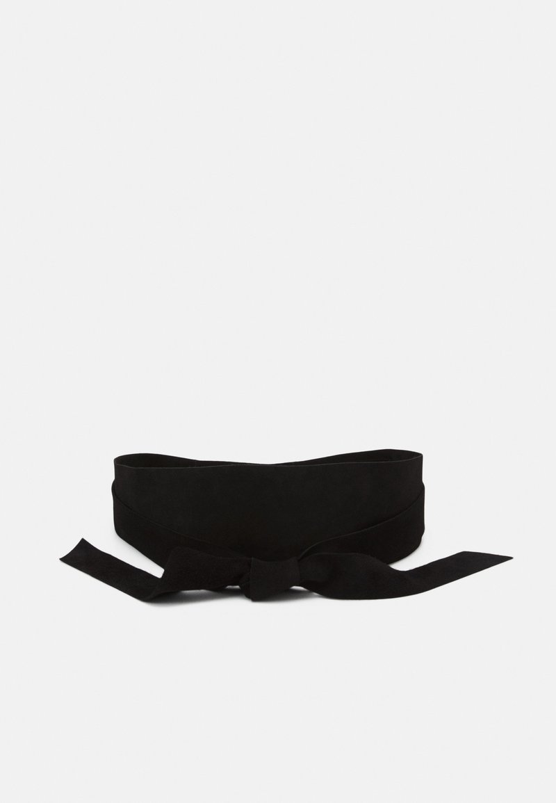 Ceinture large en tissu noir nouée en nœud avec de longues extrémités sur un fond blanc uni.