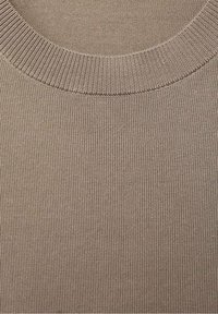 Tejido de punto acanalado beige con un escote redondeado. La textura es suave y elástica, con líneas verticales uniformemente espaciadas.