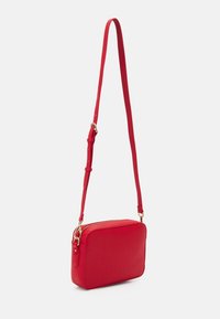 Borsa a tracolla rossa con forma rettangolare strutturata, materiale testurizzato, chiusura con cerniera superiore e tracolla regolabile.