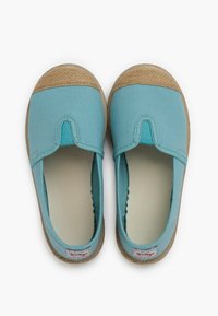 Pantofi slip-on din pânză albastru deschis, cu vârf din fibră naturală și talpă din cauciuc bej. Au o cusătură pe margine și căptușeală moale.