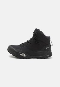 Black hiking boot with a high-top design, featuring a textured fabric upper, reinforced toe cap, and rubber sole with aggressive tread.