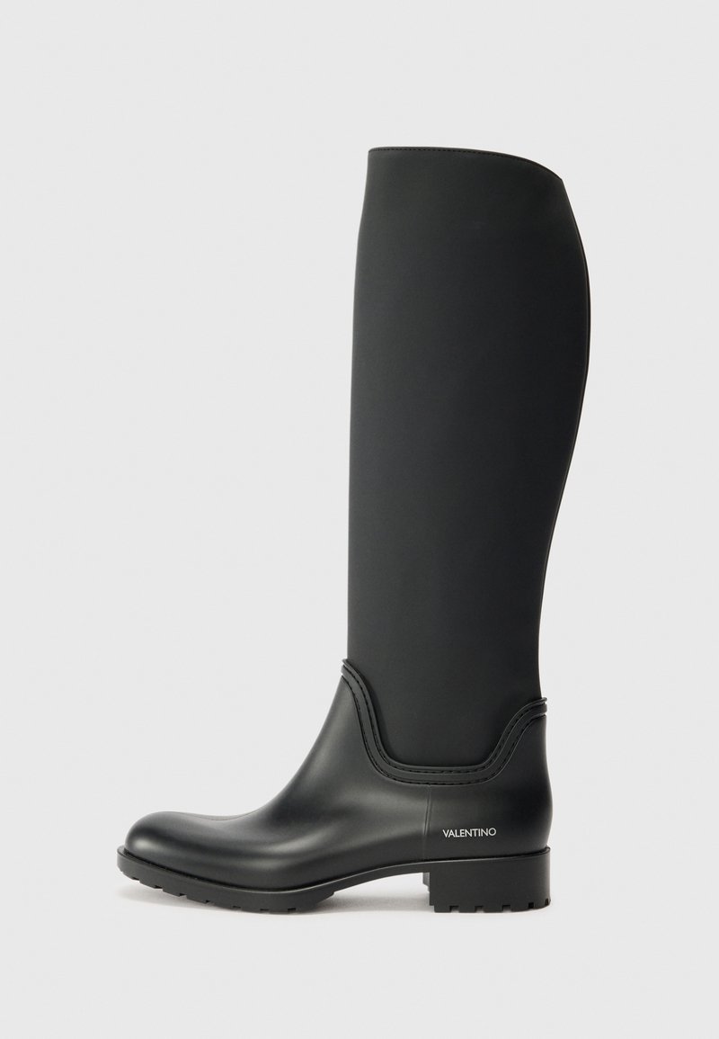 Botas de borracha pretas até ao joelho, com bico arredondado, acabamento mate e parte superior texturizada. Apresentam uma marcação subtil de lado e sola robusta.
