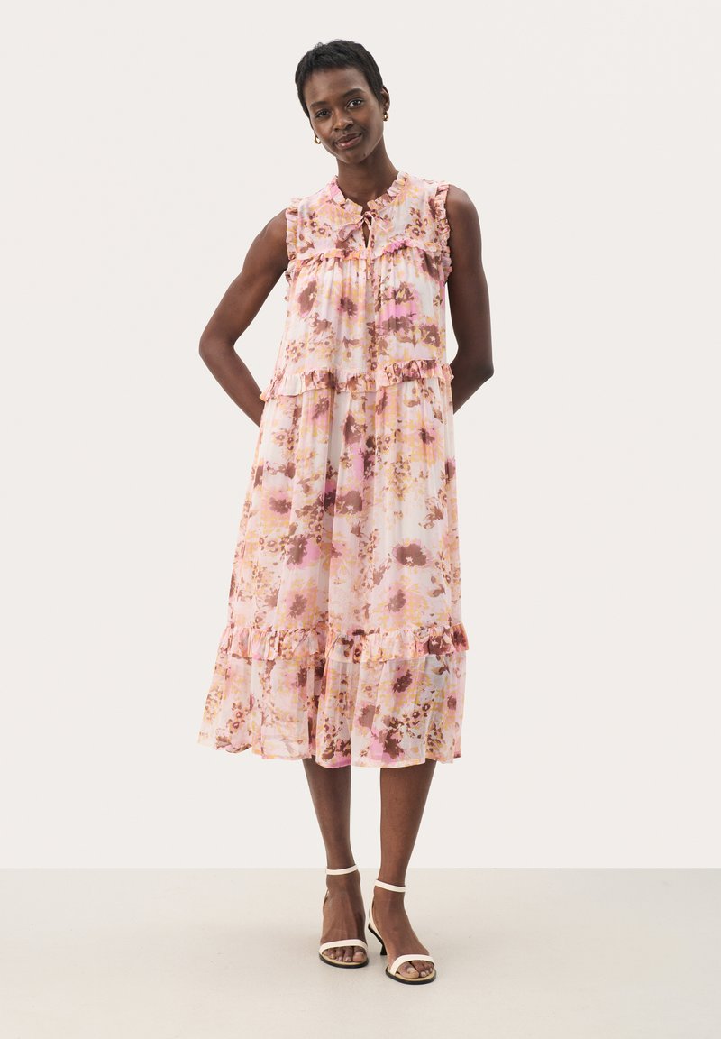 Rochie maxi florală în nuanțe de roz pal și crem, cu detalii volăne și decolteu în formă de cheie. Confecționată dintr-un material ușor și transparent.