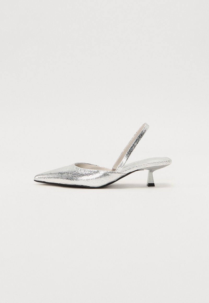 Silver slingback pump with a pointed toe, sparkly texture, slight heel, and a cutout for the ankle strap. Sleek and modern shape.