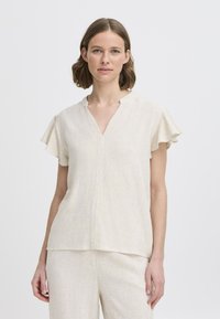 Top corto a maniche corte beige chiaro con scollatura a V e maniche arricciate, realizzato in un tessuto testurizzato. Design a strati che scende leggermente sotto la vita.