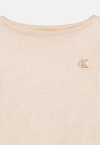 Βεραμάν κοντομάνικο τοπ με λαμπερή υφή. Διαθέτει στρογγυλή λαιμόκοψη και κεντημένο λογότυπο στη γωνία. 