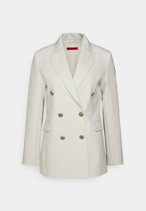 Blazer crème à double boutonnage avec revers crantés, boutons dorés et poches avant. Fabriqué en tissu lisse, il présente une coupe ajustée.