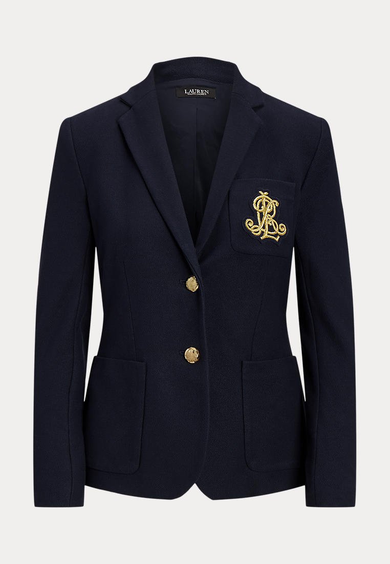 Blazer bleu marine avec boutons dorés, deux poches avant et un logo doré brodé sur la poche poitrine, taillé pour une coupe ajustée.