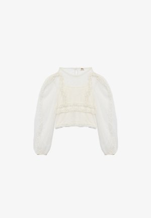 Blusa blanca recortada con mangas abullonadas, tela texturizada con pequeños puntos elevados y acentos de volantes a lo largo del escote y el dobladillo.