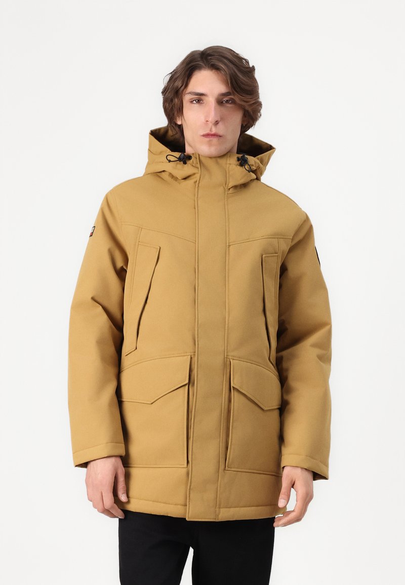Chaqueta parka color beige con cremallera frontal, grandes bolsillos con parche y capucha ajustable. Hecha de un tejido texturizado, adecuada para el clima frío.