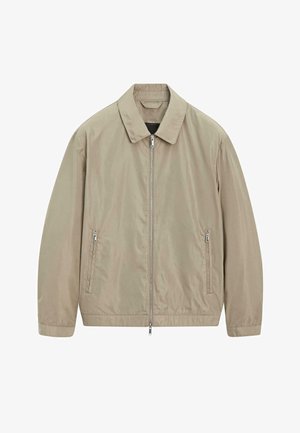 Beige lichtgewicht jas met een volledige ritssluiting aan de voorkant, twee zijzakken met rits, lange mouwen en een klassieke kraag.