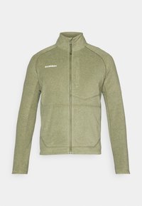 Giacca in pile verde oliva con zip, caratterizzata da un colletto alto, tessuto testurizzato e cuciture a contrasto. Nome del marchio "Mammut" stampato sul petto.